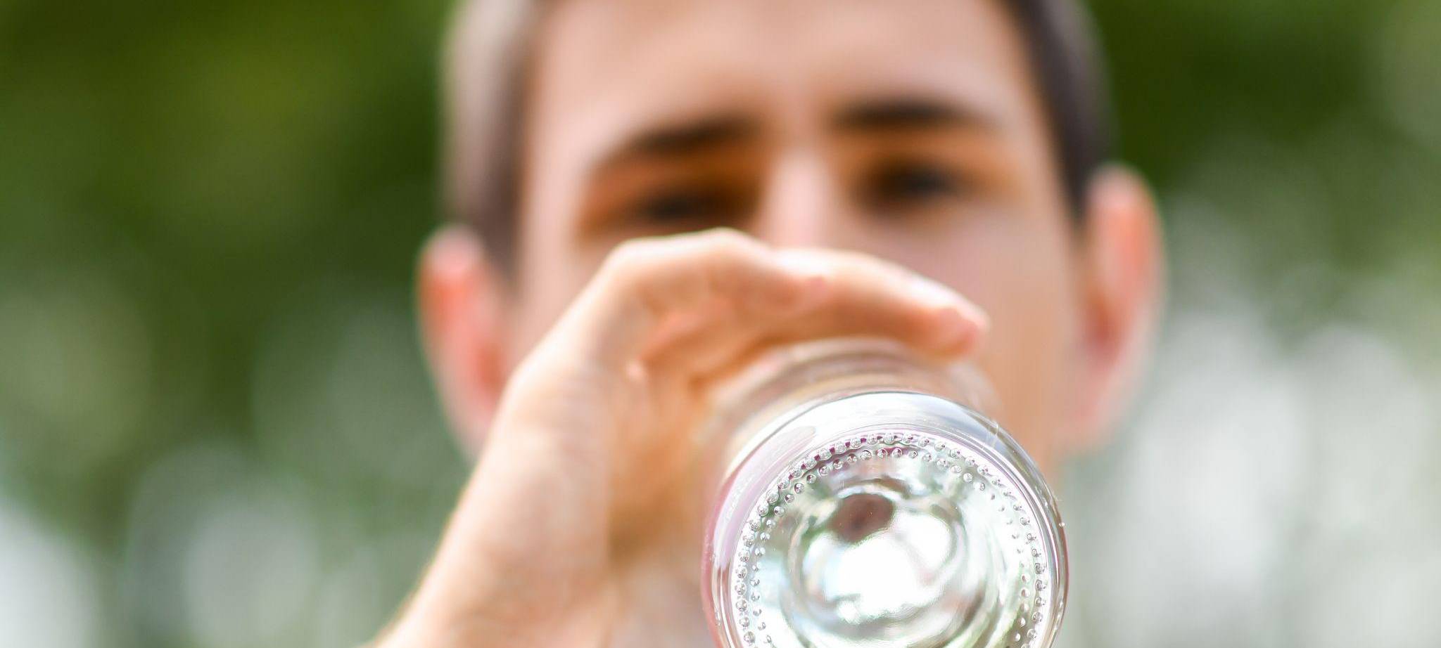 Mann trinkt aus einer Flasche Mineralwasser